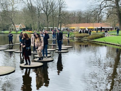 People walking across the stepping stones in the river at Keukenhof