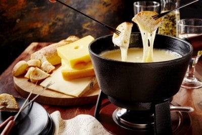 A bowl of Swiss fondue with bread and cheese