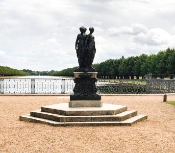 Part of the palace gardens with a statue and a view of the Long Water canal