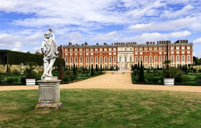 Part of the gardens and palace with a statue in the foreground