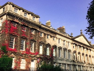 A Georgian building in Bath - part of it has colourful vines creeping up the front