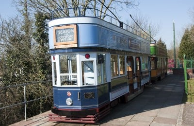 A blue open top tram that you can ride on on the SeatonTramway
