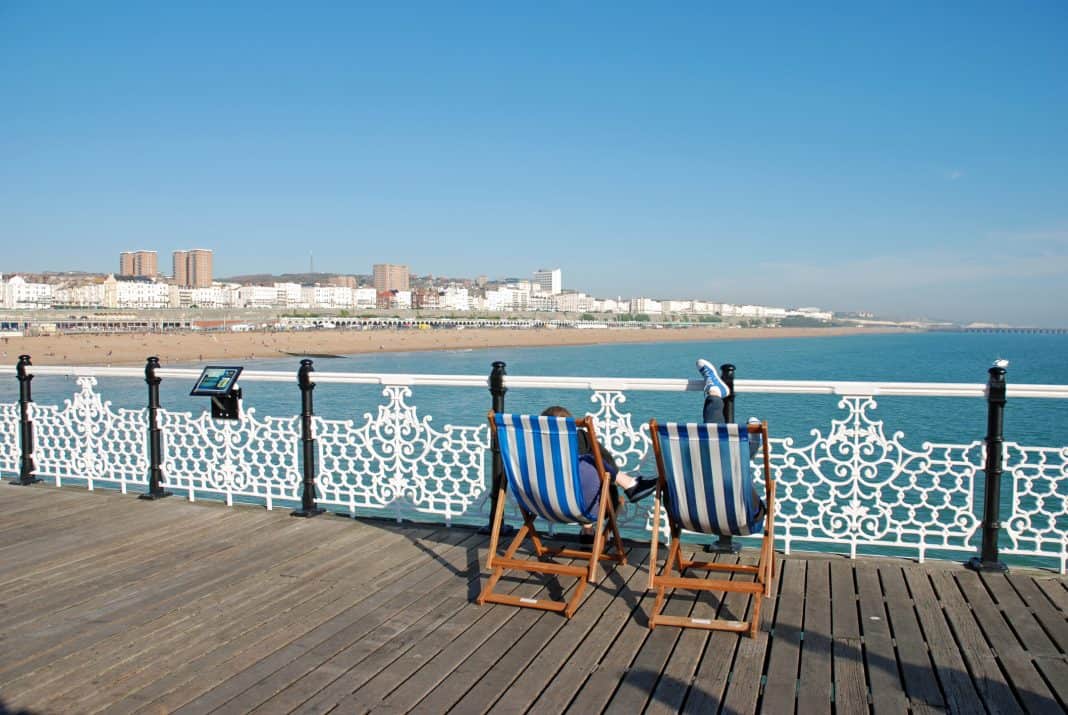 People sitting in deckchairs relaxing on Brighton pier