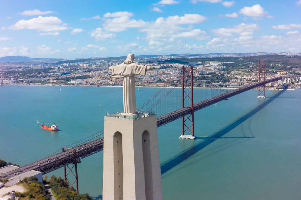 The Christ statue in Lisbon overlooking the bridge and river