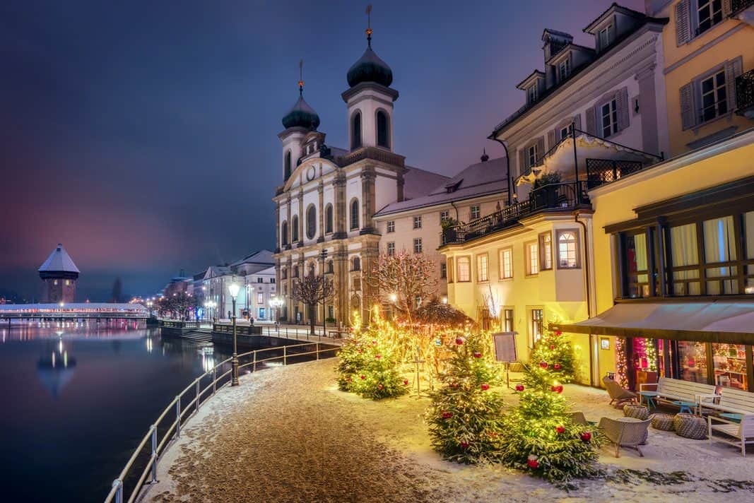 An image of the Jesuit Church at night with Christmas trees in front