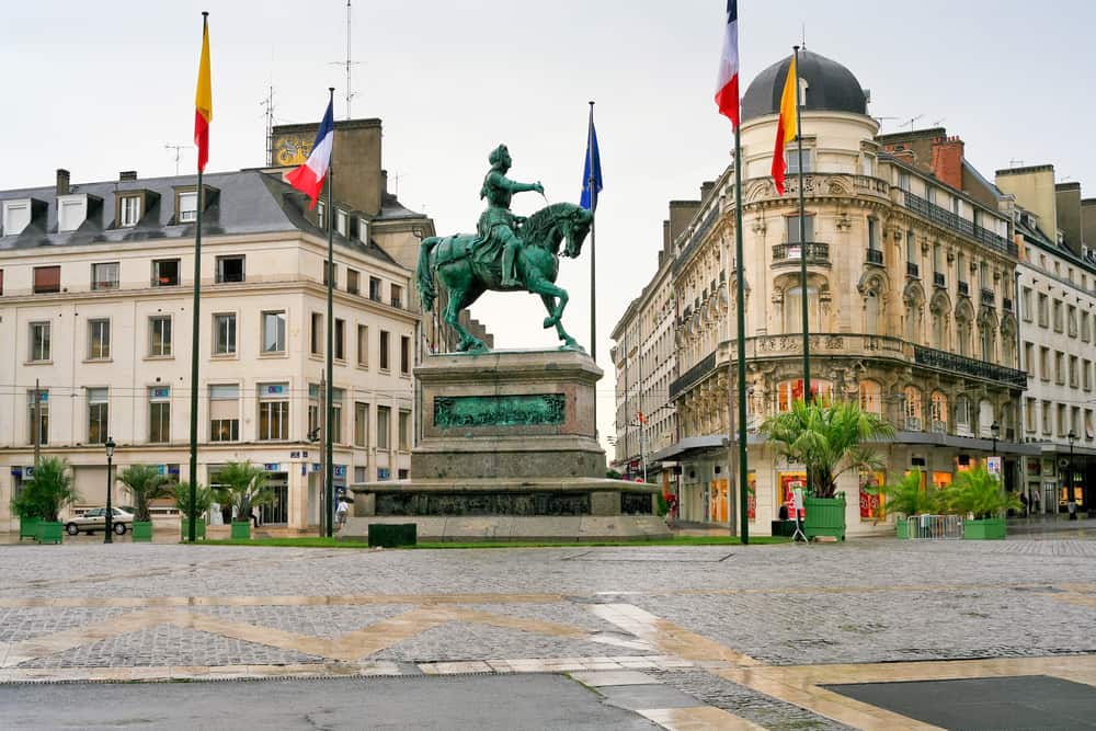 The Joan of Arc monument in a square in Orleans surrounded by buildings