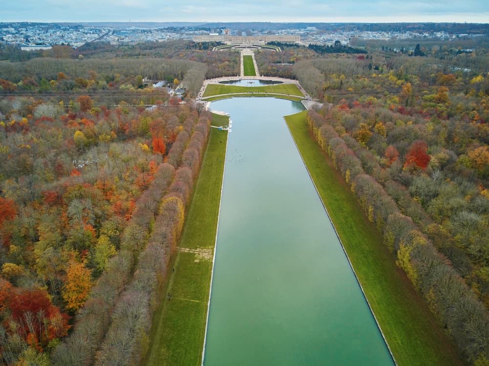 An aerial view of the Grand Canal in Versailles surrounded by trees