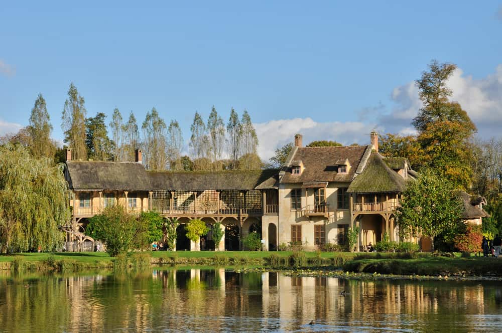 Old rustic buildings by a lake in the Queen's Hamlet