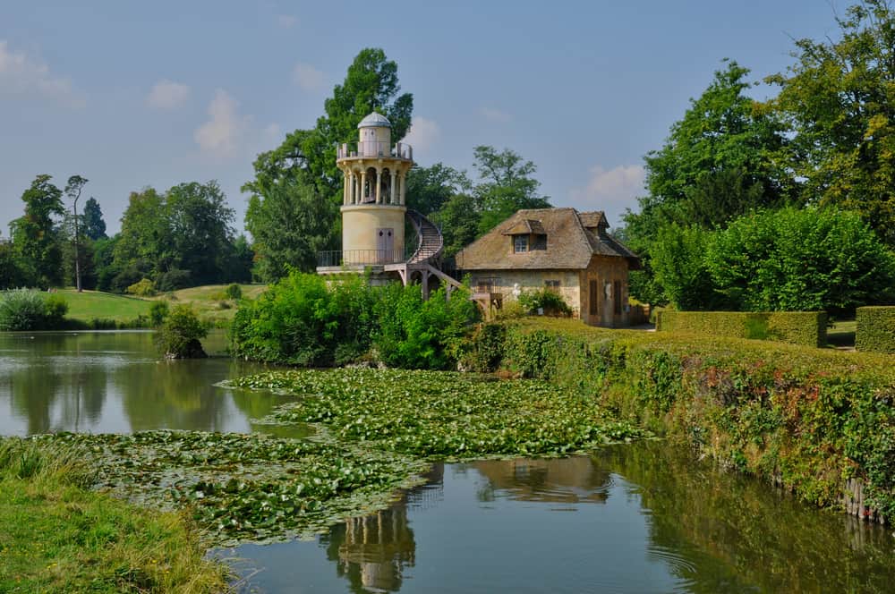 A tower and small building by a lake in the Queen's Hamlet