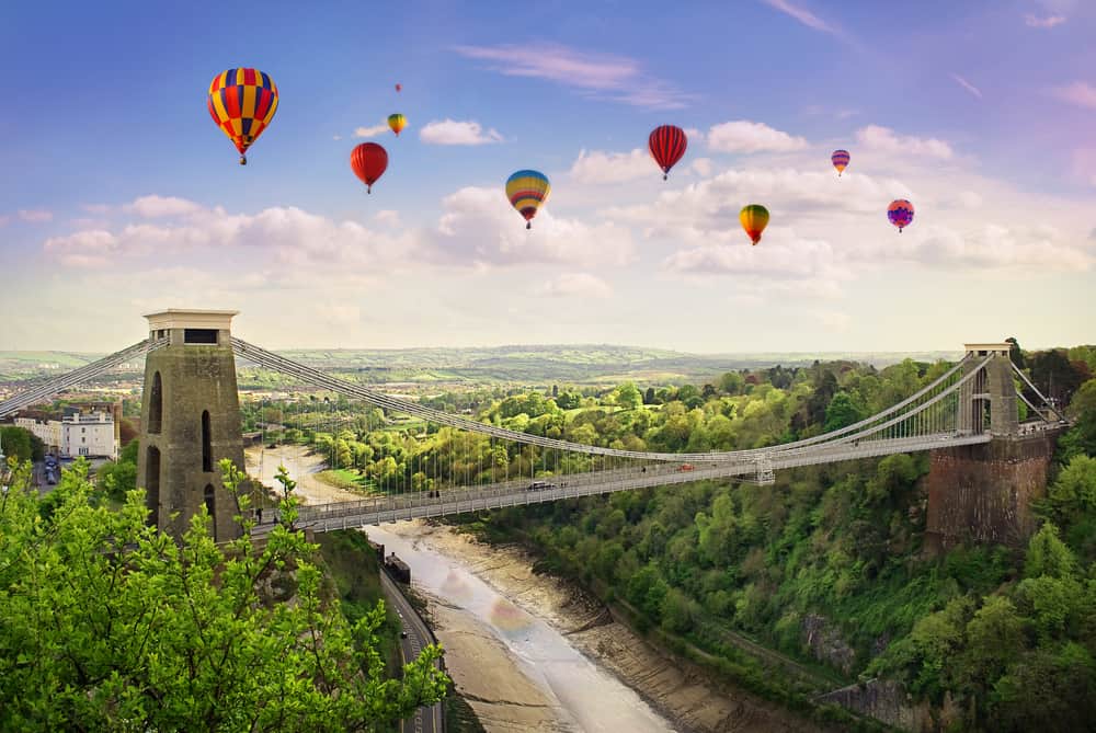 The Clifton Suspension Bridge in Bristol with hot air balloons floating in the sky