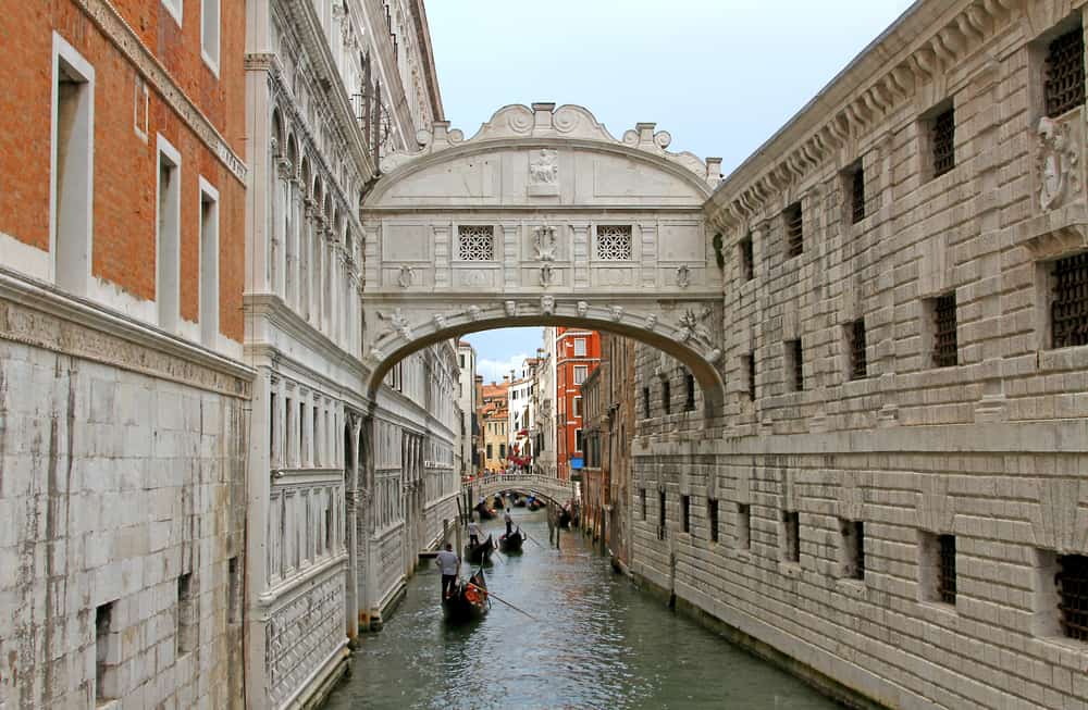 The Bridge of Sighs in Venice with gondolas sailing beneath it