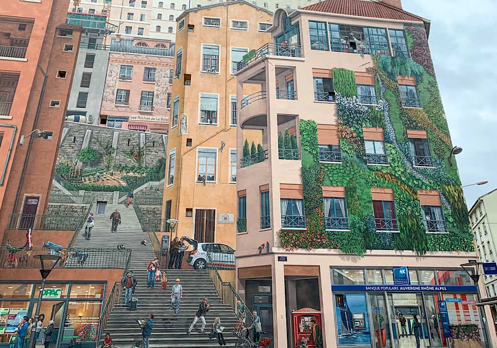 The Mur des Canuts mural.  This is a huge mural covering the entirety of the side of a building.  It is very lifelike and shows buildings, shops and steps.  A visit here is a must on 2 days in Lyon