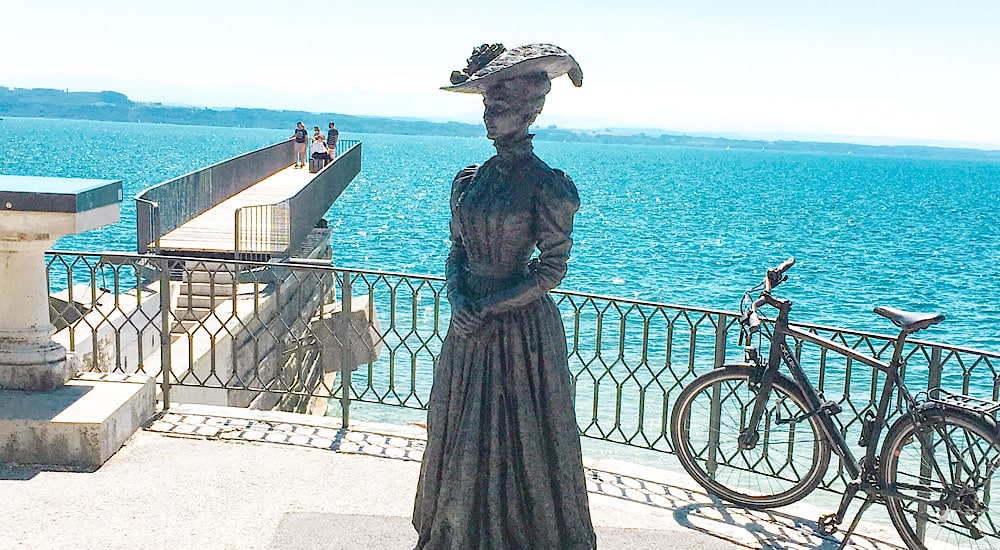 A Belle Epoque statue of a woman in old costume in Neuchatel by the lakeside