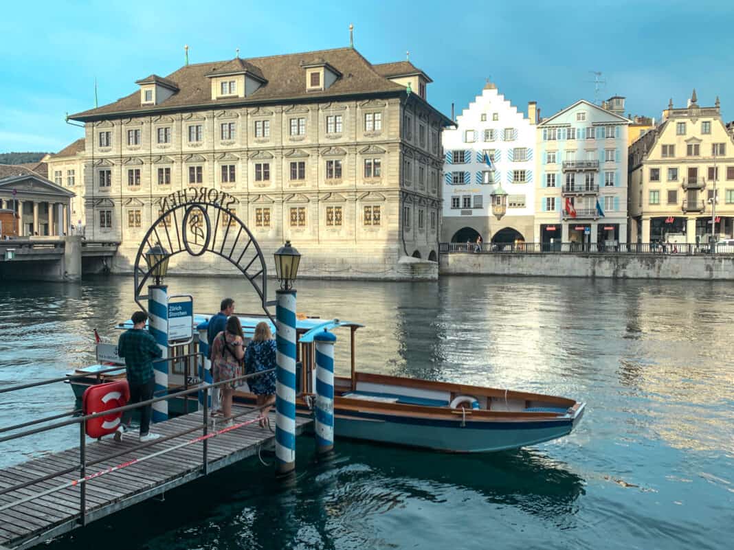 A view of part of the river in Zurich with a small boat on it and a boat stop