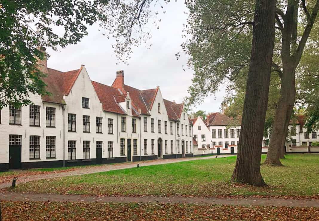Bruges' beguinage - small whitewashed houses with trees and grass in front
